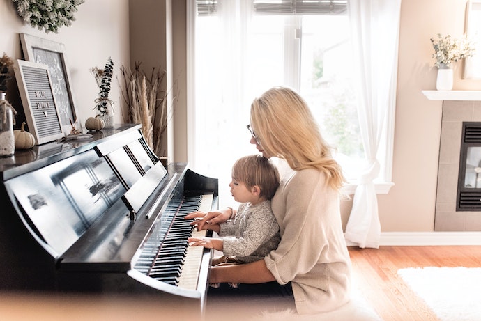 a mom teaches her son to play piano