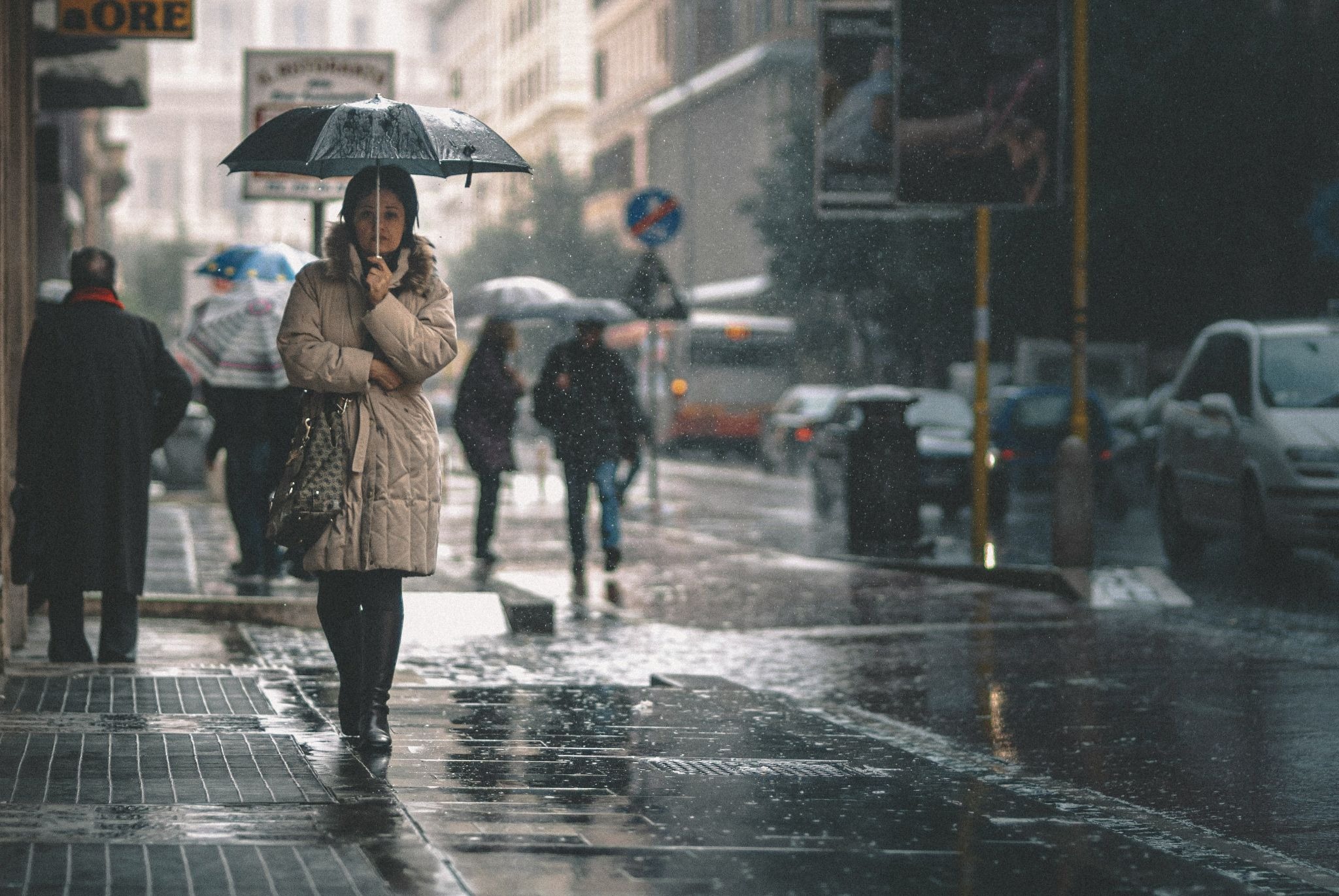people with umbrellas in raining street
