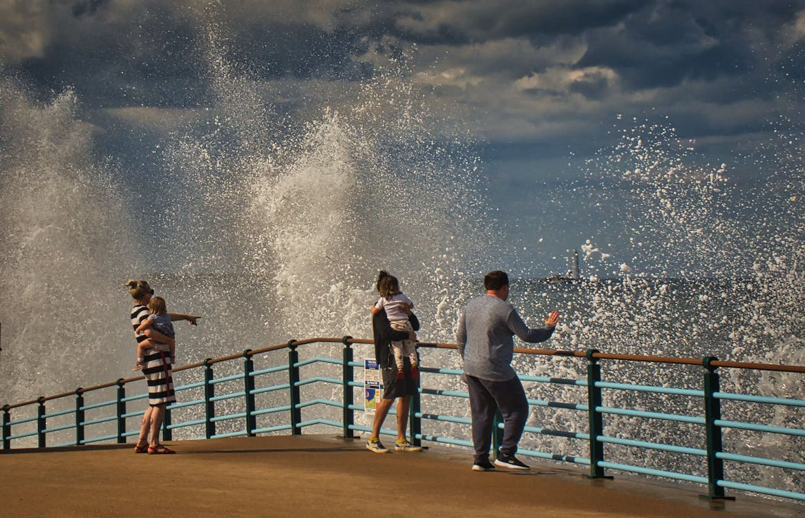 Family watch as waves crash