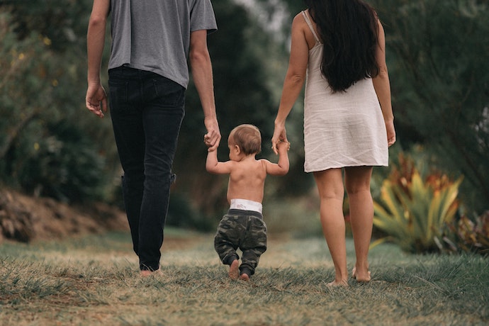 a young family walk barefoot in woods