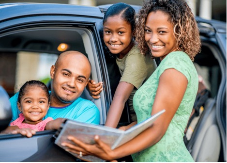 Family looking at a map book on a roadtrip