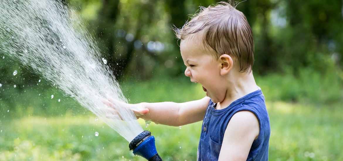 Happy toddler with a hosepipe