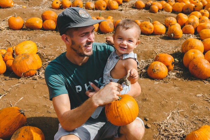 A dad with his son in pumpkin patch