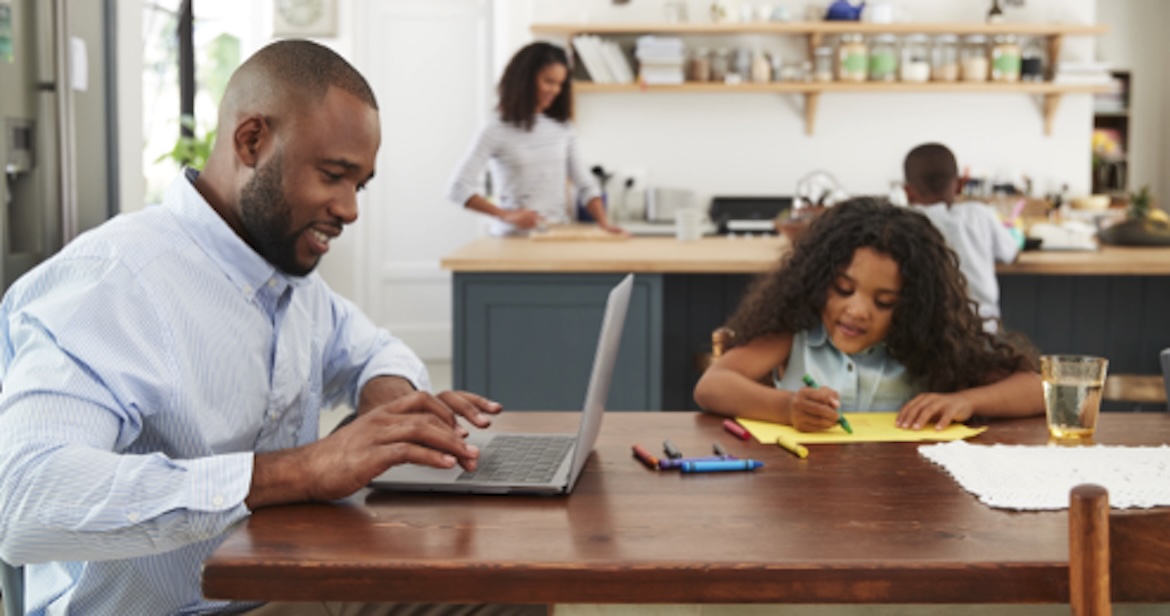 dad on laptop and daughter playing