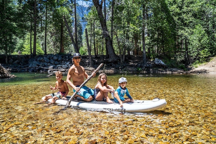 family on a paddle-board in clear water
