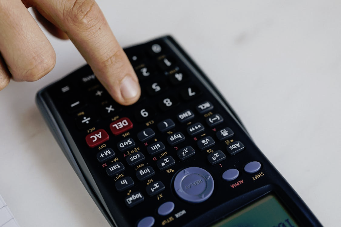 Close-up image of a finger reaching to press a calculator