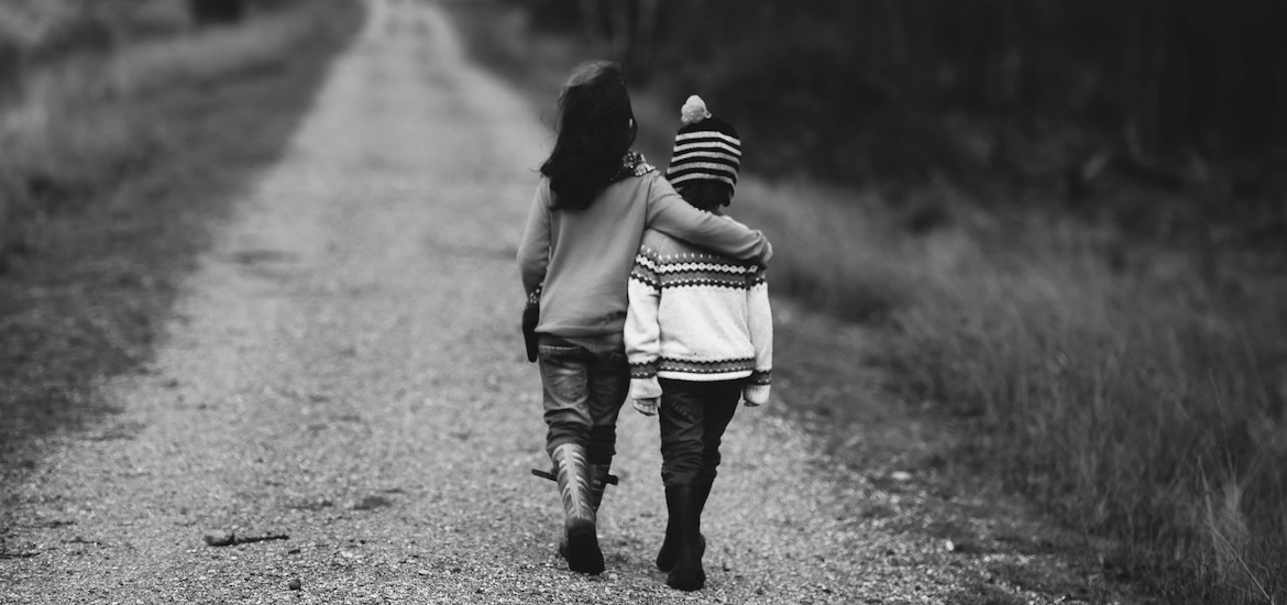 A sister with her arm around her brother