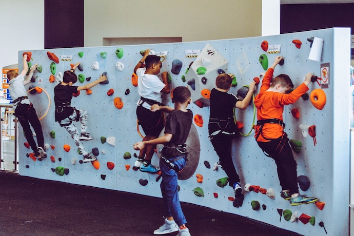kids learning climbing on a small climbing wall