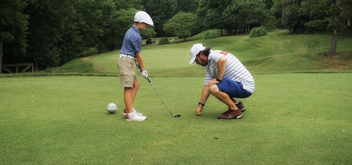 Dad teaches son to play golf