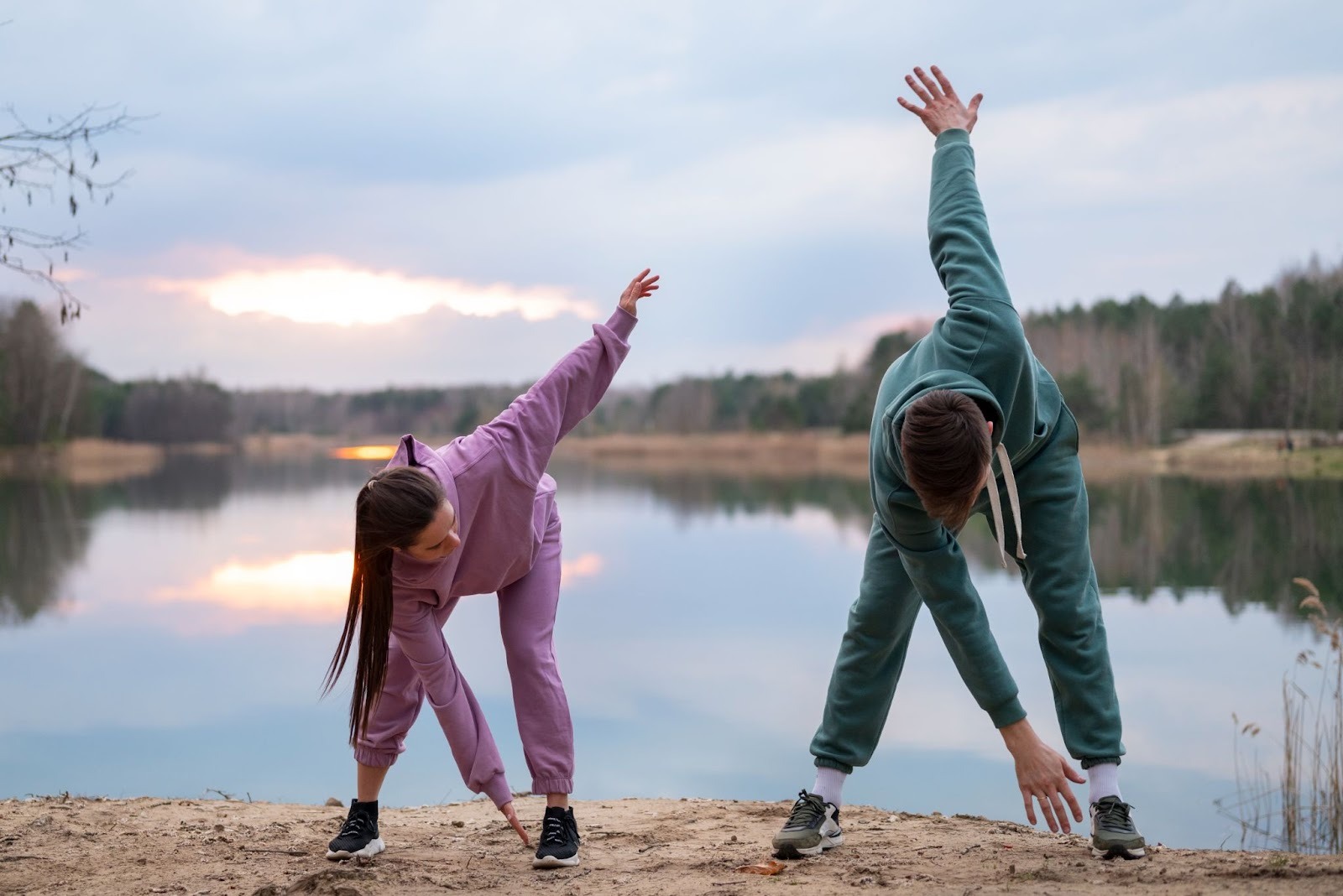 Couple doing yoga at sunrise