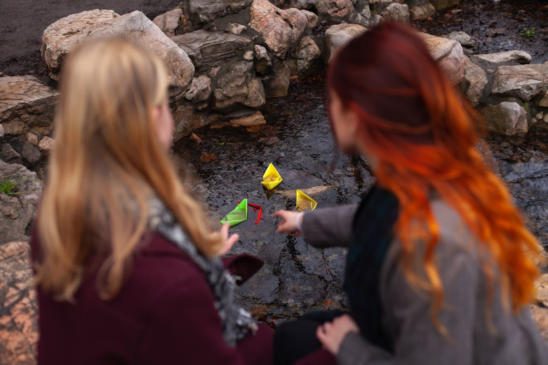 mum and daughter play by creek
