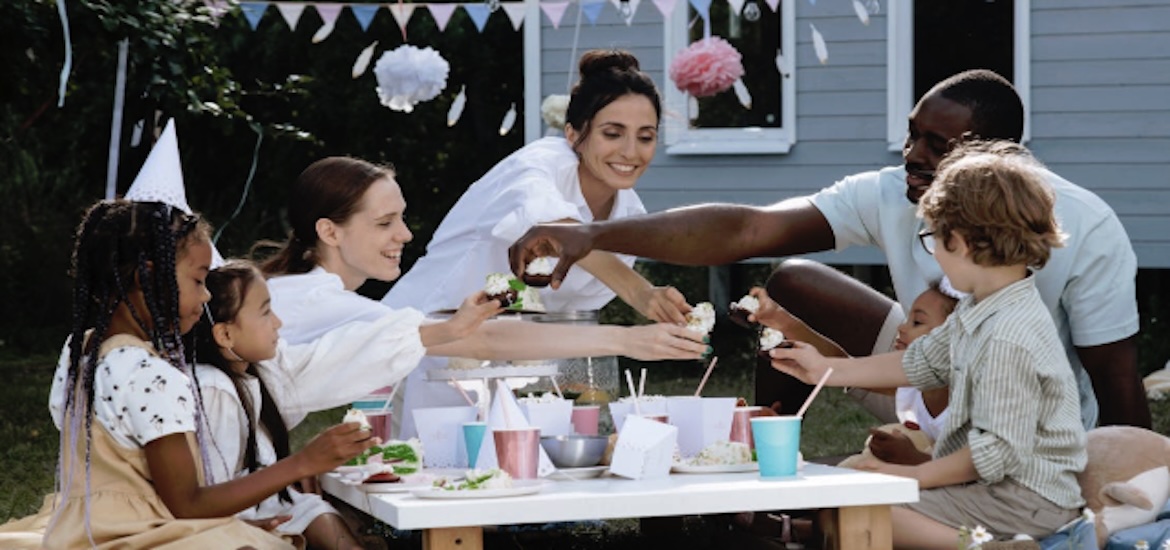 A diverse family group enjoy a party outdoors