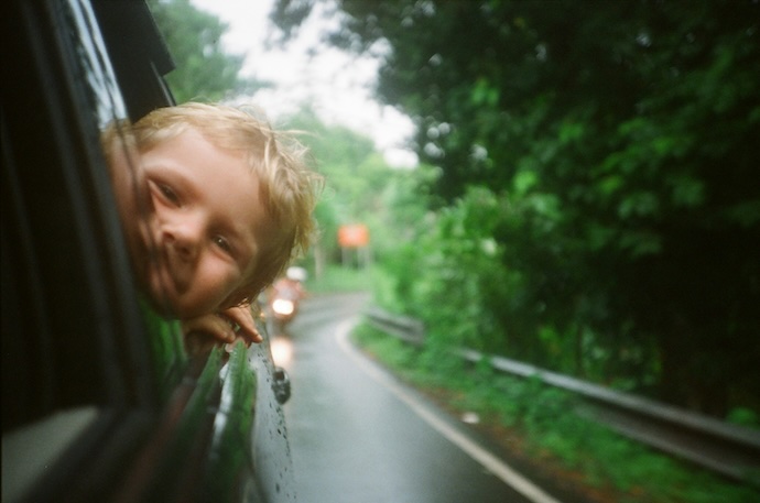 kid leaning out of car window