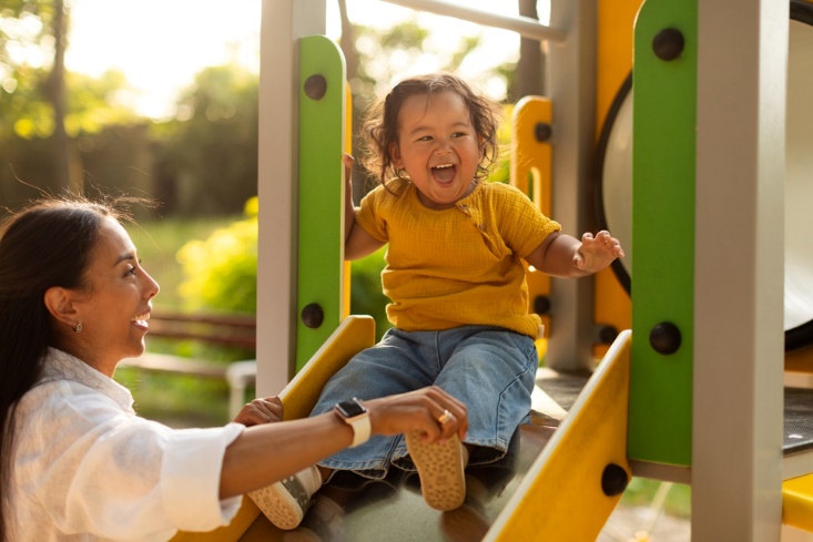 kid on slide with mum