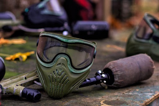 Protective goggles next to a paintball marker