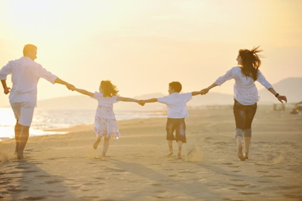 a family on a beach at sunset