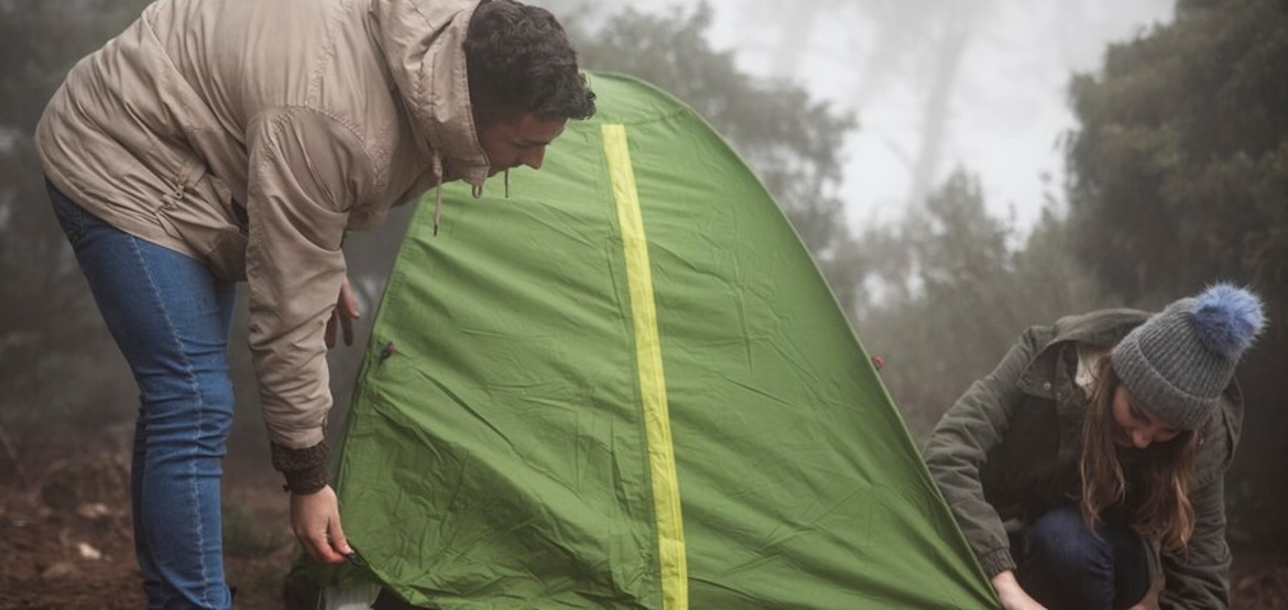 2 people putting up a tent together