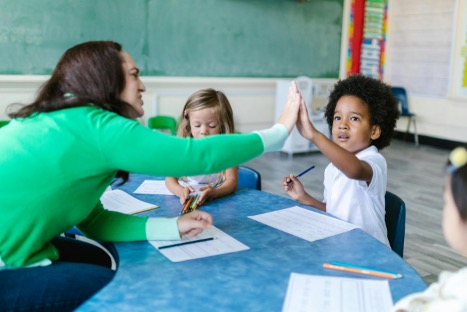 Teacher high fives child in class