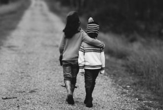 A sister with her arm around her brother