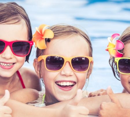 Three kids having fun in the pool and enjoying water activities