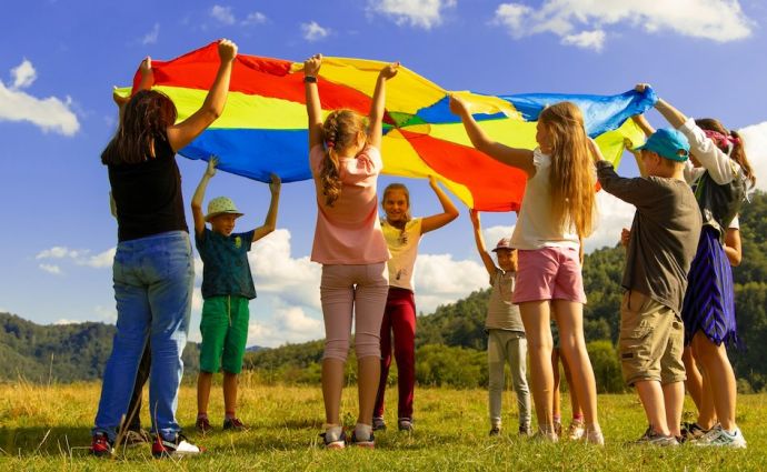 kids play outside in sun with big flag banner