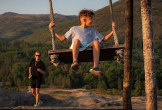 A kid enjoying the swing outdoors