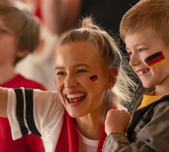 A mum and son cheer at a soccer game