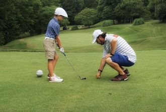 Dad teaches son to play golf