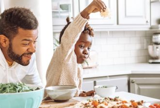 Family making homemade pizza together for National Pizza Day