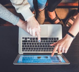 hands of family pointing at computer laptop online safety for kids family days out