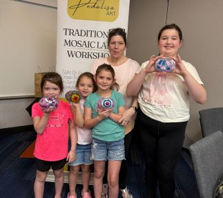 Family-friendly Turkish mosaic lamp workshop in Houston with children proudly holding handmade colorful mosaic lamps at Pedalisa Art studio