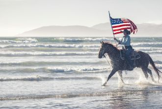 Man riding a horse with American flag