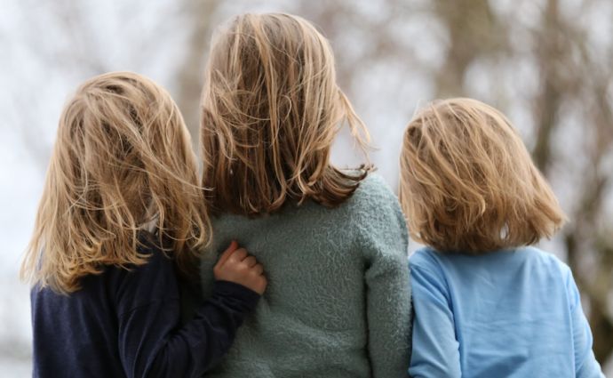 siblings children back of heads hugging