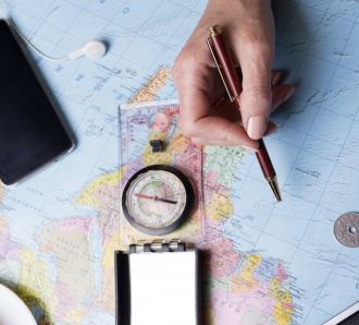 a hand studying a map and travel details