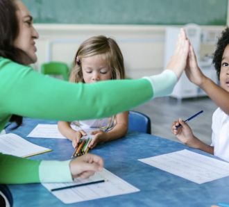 Teacher high fives child in class
