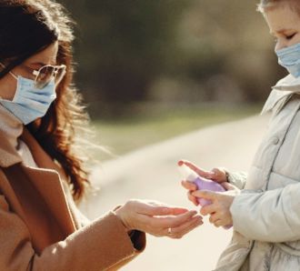 Mum giving daughter hand sanitsier