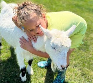 old mcdonald's farm girl hugging goat
