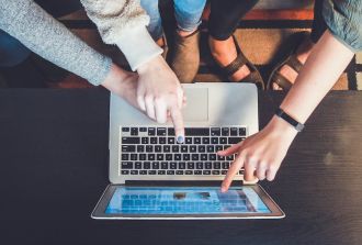 hands of family pointing at computer laptop online safety for kids family days out