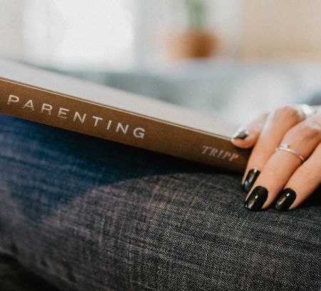 a moms hand on a parenting book