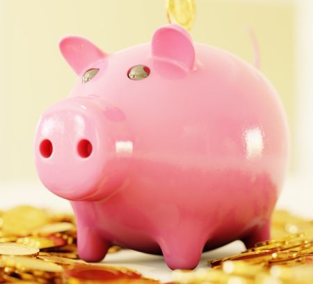 A pink piggy bank with gold coins