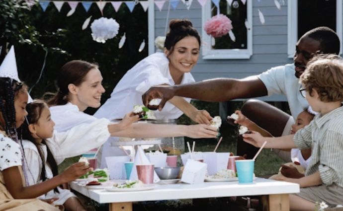 A diverse family group enjoy a party outdoors