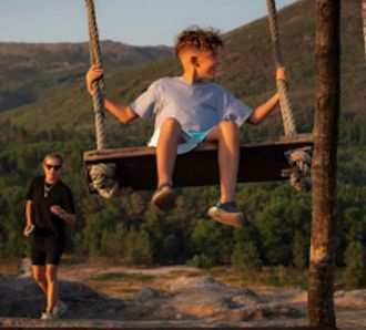 A kid enjoying the swing outdoors