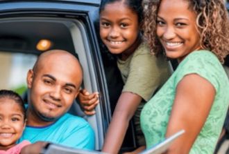 Family looking at a map book on a roadtrip