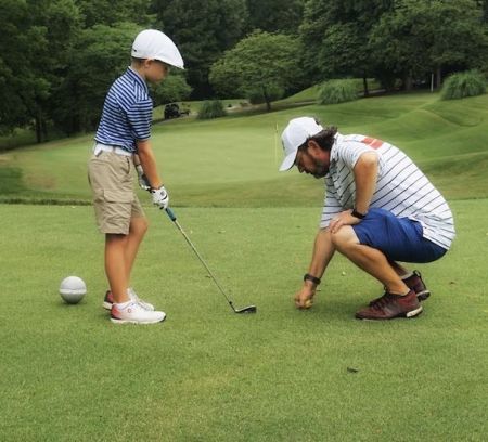 Dad teaches son to play golf