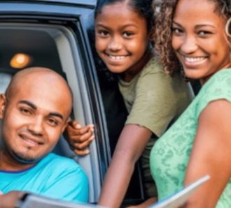Family looking at a map book on a roadtrip