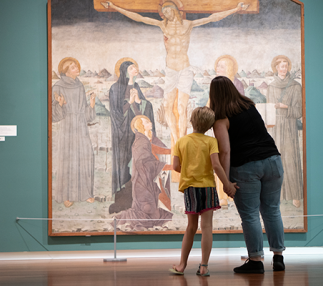 An adult and a child look at a work of art.