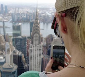 A lady takes a photo of the Chrysler building from Summit One