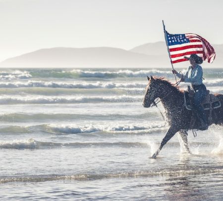 Man riding a horse with American flag
