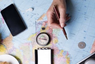 a hand studying a map and travel details