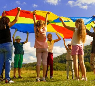 kids play outside in sun with big flag banner